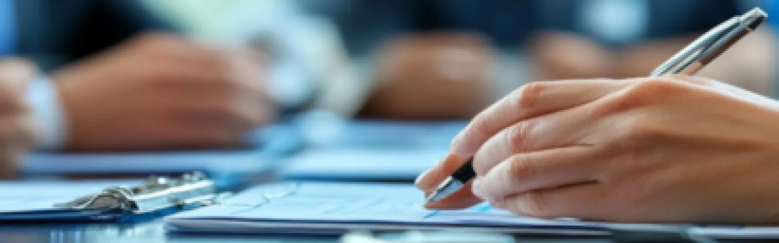Hands at a meeting, writing
